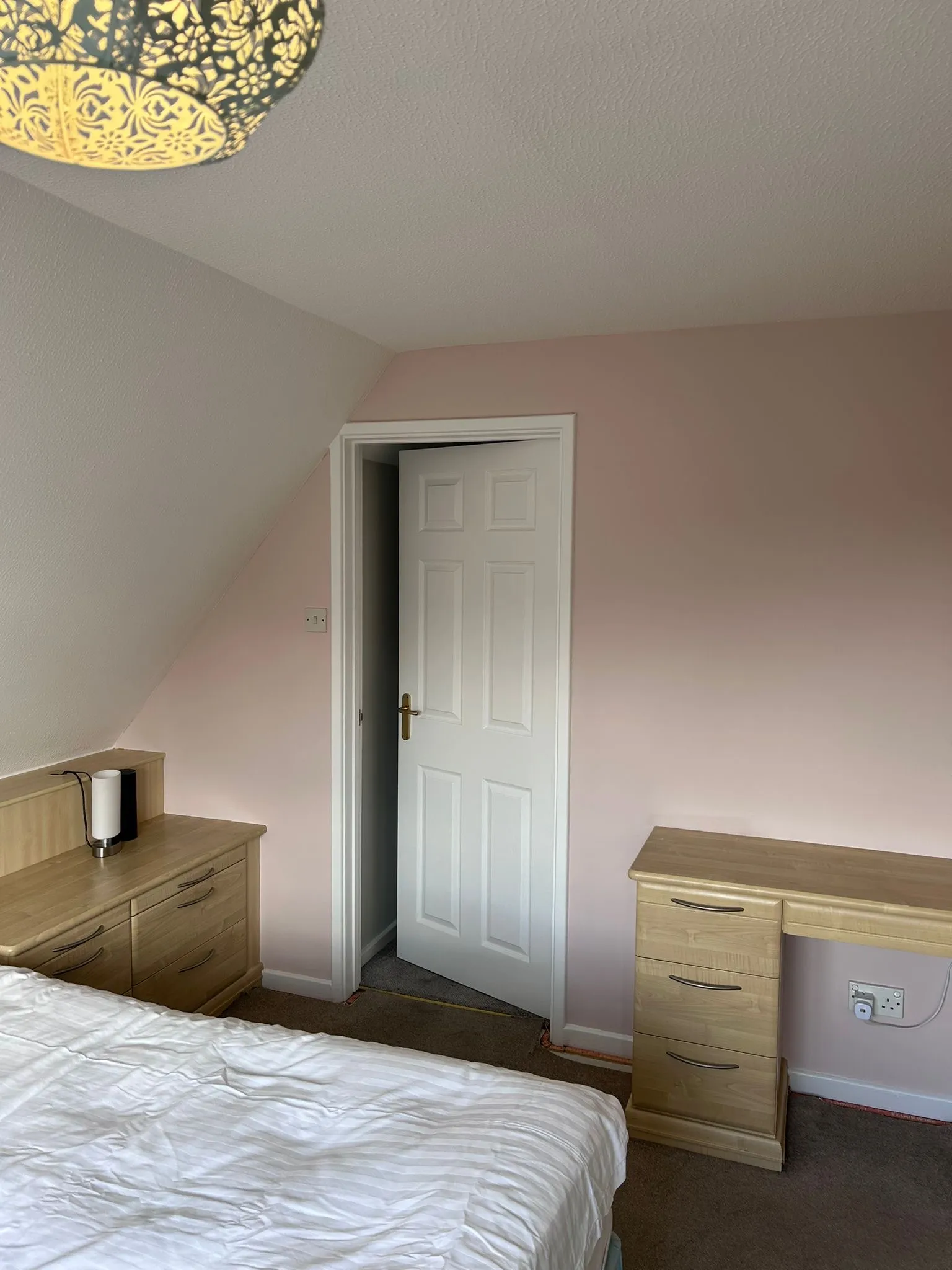 Corner of the redecorated bedroom showing the finished paintwork beside the door