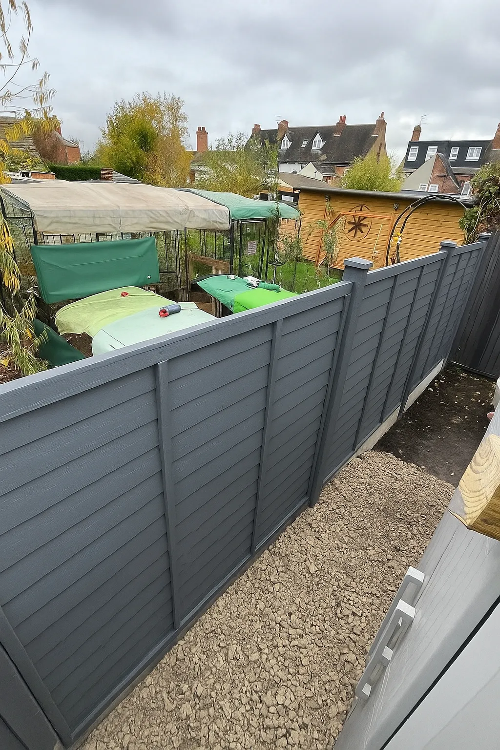 Renovated garden with new dark grey fence panels and a paved area
