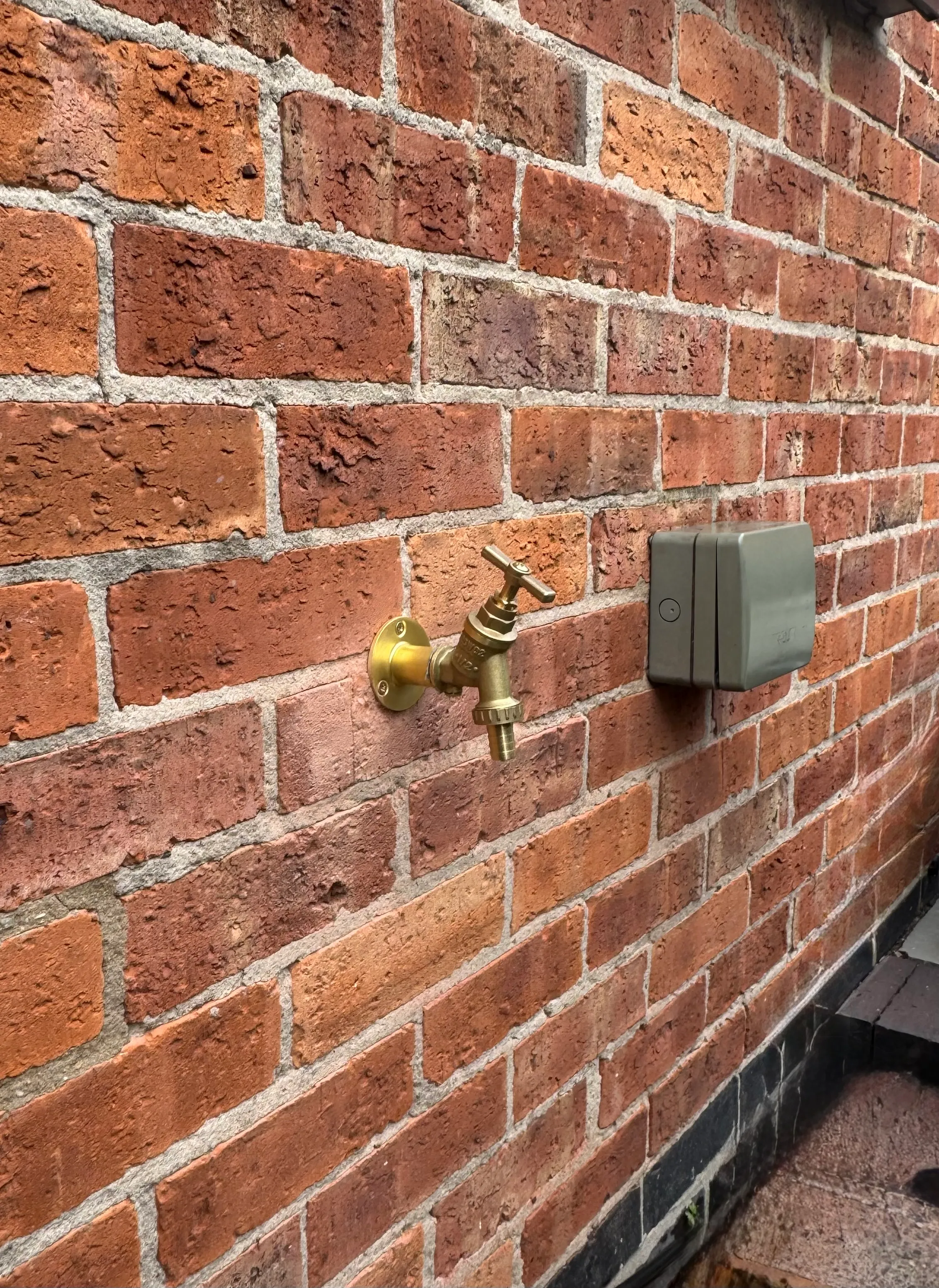 Outdoor tap fitted to a brick wall by our plumbing team
