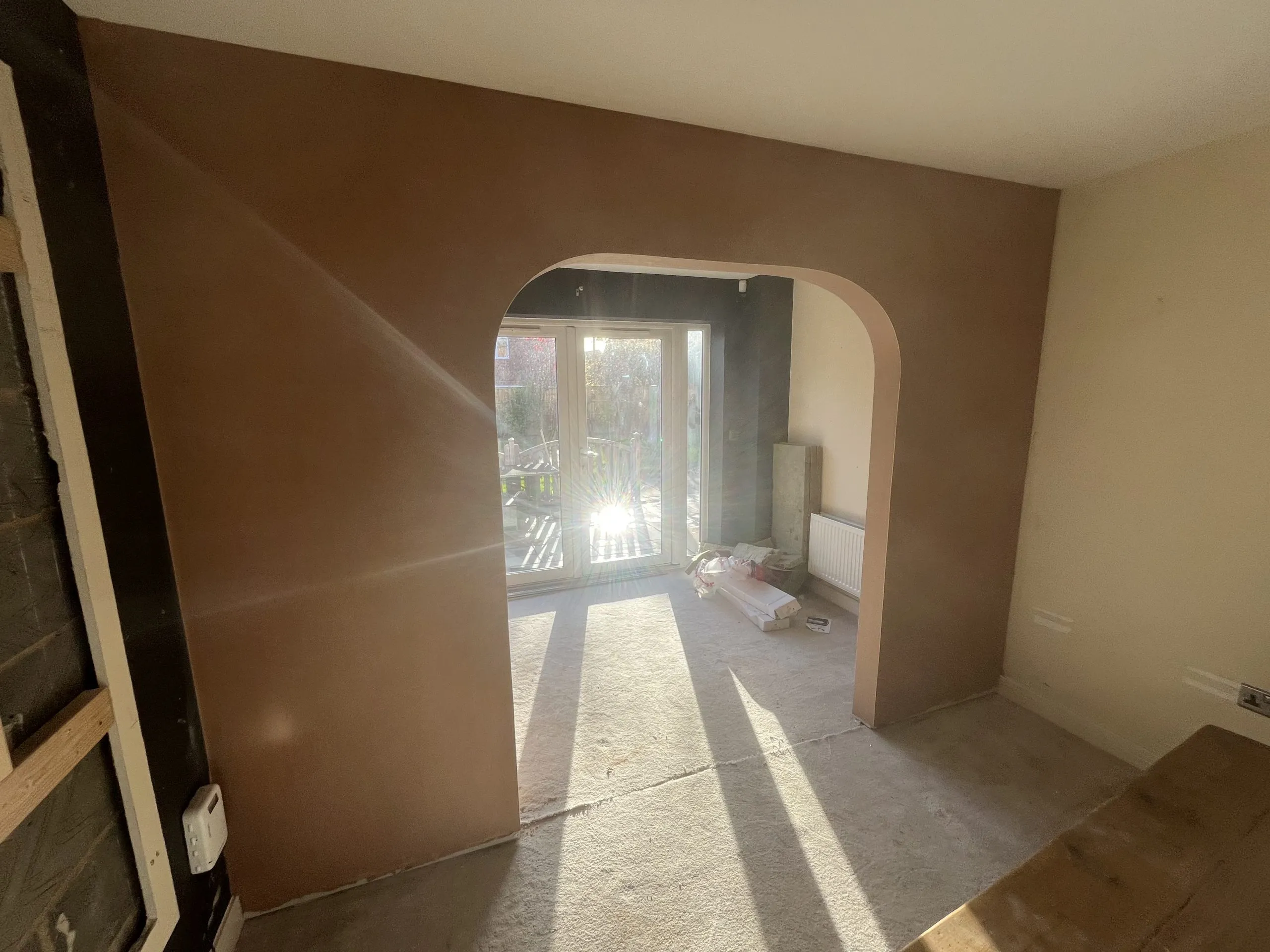 Room stripped back to bare plaster during a full renovation